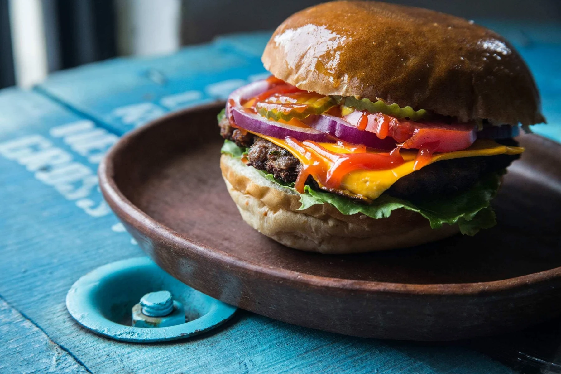Hamburguesa de Burger Planet fotografiada sobre una mesa azul